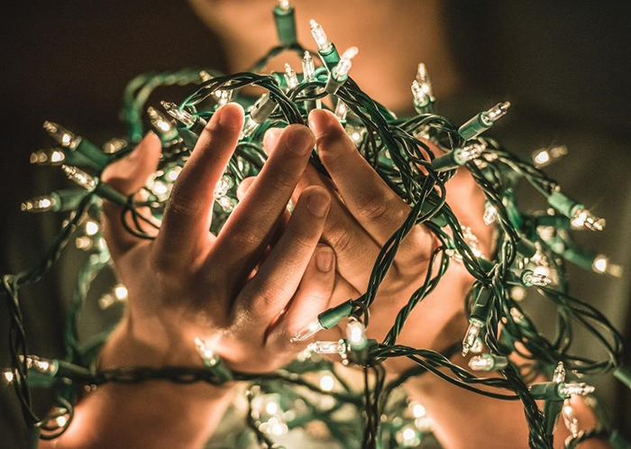 String of holiday lights held in hands